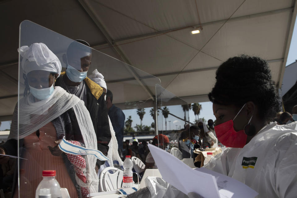 Ethiopian immigrants arrive at the Ben Gurion airport near Tel Aviv, Israel, Thursday, Dec. 3, 2020. Hundreds of Ethiopian immigrants on Thursday arrived to a festive ceremony at Israel's international airport, as the government took a step toward carrying out its pledge to reunite hundreds of families split between the two countries. (AP Photo/Sebastian Scheiner)