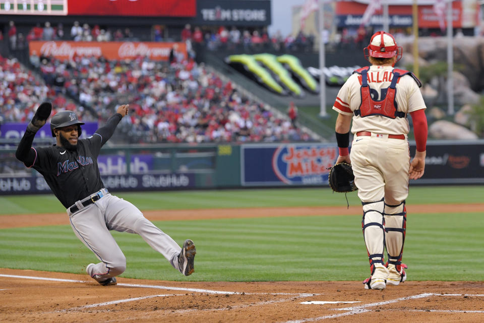 Miami Marlins' Bryan De La Cruz, left, scores on a single by Jean Segura as Los Angeles Angels catcher Chad Wallach stands at the plate during the second inning of a baseball game Friday, May 26, 2023, in Anaheim, Calif. (AP Photo/Mark J. Terrill)