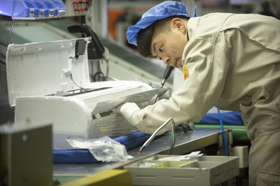 In this Feb. 24, 2017, photo, a factory worker assembles the case of an air conditioner on an assembly line at a Haier factory in Jiaozhou near Qingdao in eastern China's Shandong Province. U.S. President Donald Trump's latest tariff hike on Chinese goods took effect Friday, May 10, 2019, and Beijing said it would retaliate, escalating a battle over China's technology ambitions and other trade tensions. (AP Photo/Mark Schiefelbein)