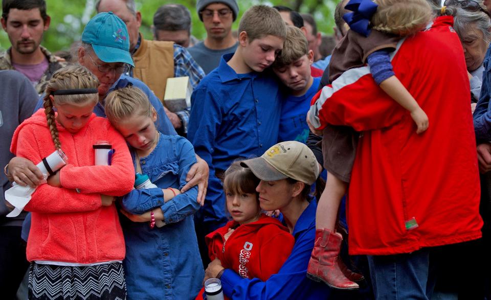 Becky Jones, lower center in blue shirt and tan hat, mourns during a candlelight vigil on Tuesday, May 11, 2021, for her husband, Concho County sheriff's deputy Stephen Jones, who was killed Monday night in Eden.