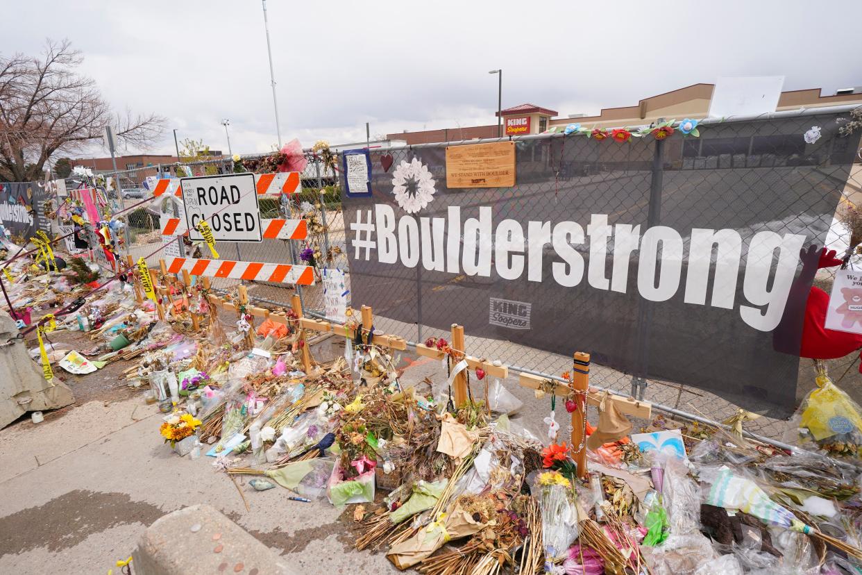 Tributes cover the temporary fence around the King Soopers grocery store in which 10 people died in a mass shooting in late March on Friday, April 23, in Boulder, Colo. 