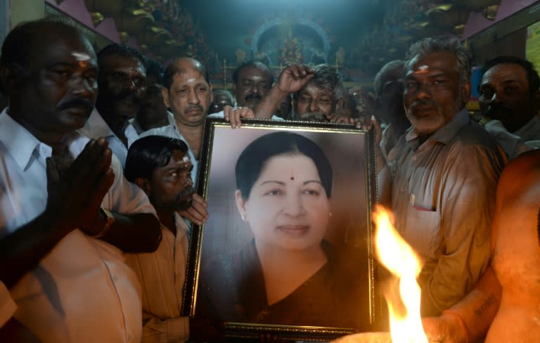 Supporters hold a photograph of Tamil Nadu state leader Jayalalithaa Jayaram as they offer prayers for her well being at a temple in Mumbai on December 5, 2016