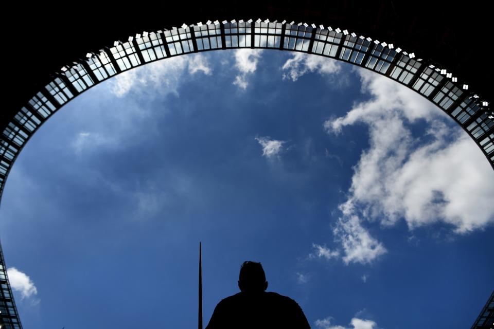 A javelin thrower stands in the shade at the Tokyo Olympics.