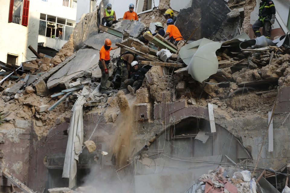 Chilean and Lebanese rescuers search in the rubble of a building that was collapsed in last month's massive explosion, after getting signals there may be a survivor under the rubble, in Beirut, Lebanon, Thursday, Sept. 3, 2020. Hopes were raised after the dog of a Chilean search and rescue team touring Gemmayzeh street, one of the hardest-hit in Beirut, ran toward the collapsed building. (AP Photo/Bilal Hussein)