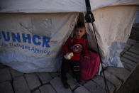 A Syrian boy who is newly displaced by the Turkish military operation in northeastern Syria, stands at the entrance to his tent at the Bardarash camp, north of Mosul, Iraq, Wednesday, Oct. 16, 2019. The camp used to host Iraqis displaced from Mosul during the fight against the Islamic State group and was closed two years ago. The U.N. says more around 160,000 Syrians have been displaced since the Turkish operation started last week, most of them internally in Syria. (AP Photo/Hussein Malla)