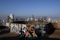 Visitors sit on the roof top of an abandoned building in Bangkok. The abandoned building, known as Sathorn Unique, dubbed the 'ghost tower' was destined to become one of Bangkok's most luxurious residential addresses but construction was never completed as the Thai economy was hit during the 1997 Asian Financial Crisis. Now, many travellers visit and explore the 49-story skyscraper. (REUTERS/Athit Perawongmetha)