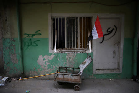 A flag of Iraq is seen outside a house on a street controlled by Iraqi Federal Police in western Mosul, Iraq, April 12, 2017. REUTERS/Andres Martinez Casares