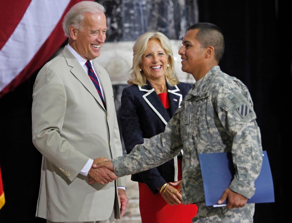 Joe Biden, then vice president, shakes hands with a U.S. Army soldier after his swearing-in at a naturalization ceremony at al-Faw Palace in Baghdad, Iraq, July 4, 2010. Jill Biden, center,  wrote the children's book "Don't Forget, God Bless Our Troops" based partly on her own family's experiences.