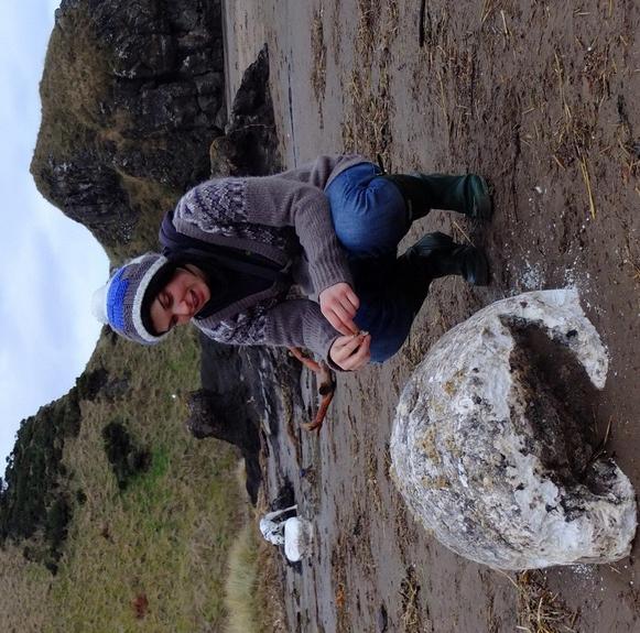 A reserve volunteer, Lainey Rees, gets a closer look at the lard, while a dog in the background enjoys investigating another chunk of the washed-up fat.