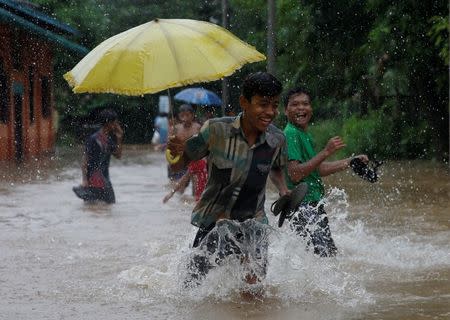 Youths play in a flooded street in Kyaikto township, Mon state, Myanmar July 22, 2017. REUTERS/Soe Zeya Tun