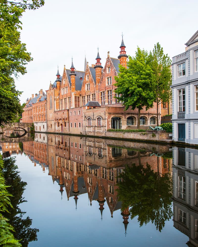 Charming canals encircle the Belgian town of Bruges. | Neil Emmerson / robertharding/Getty Images