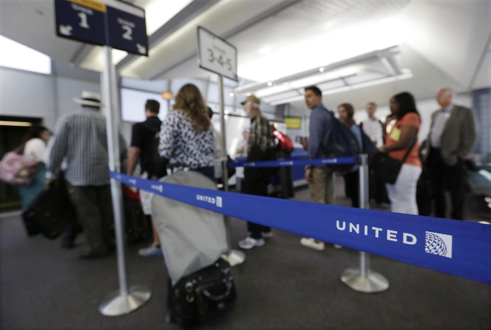 In this photo taken May 8, 2013, groups of passengers wait at a United Airlines gate to board a flight in separate numbered lanes at O'Hare International Airport in Chicago. For airlines, every minute that a plane sits at the gate makes it more likely that the flight will be late, hurting the carrier’s on-time rating and causing passengers to miss connecting flights. But the perfect boarding process remains elusive. Even an astrophysicist couldn’t figure it out. (AP Photo/M. Spencer Green)