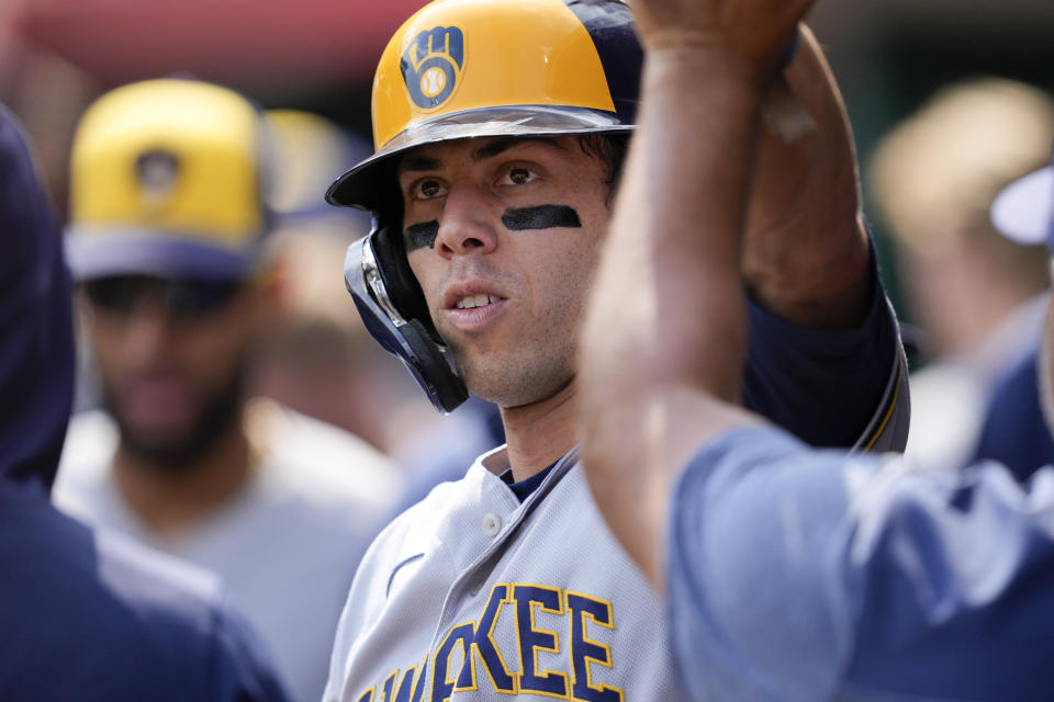 Milwaukee Brewers' Christian Yelich celebrates with teammates after scoring on a single by Rowdy Tellez in the first inning of a baseball game against the Cincinnati Reds in Cincinnati, Saturday, June 3, 2023. (AP Photo/Jeff Dean)