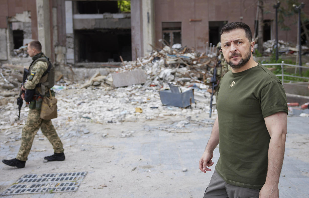 In this photo provided by the Ukrainian Presidential Press Office on Saturday, June 18, 2022, Ukrainian President Volodymyr Zelenskyy inspects damaged buildings as he visits the war-hit Mykolaiv region. (Ukrainian Presidential Press Office via AP)
