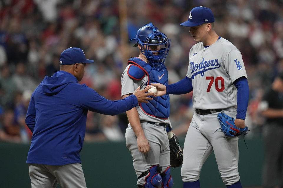 Los Angeles Dodgers' Bobby Miller (70) hands the ball to manager Dave Roberts in front of catcher Will Smith, center, as he is removed duirng the seventh inning of the team's baseball game against the Cleveland Guardians on Tuesday, Aug. 22, 2023, in Cleveland. (AP Photo/Sue Ogrocki)