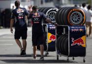 Red Bull Formula One team members move Pirelli tires near the pits at the Suzuka circuit in Suzuka October 10, 2013, ahead of Sunday's Japanese F1 Grand Prix. REUTERS/Issei Kato (JAPAN - Tags: SPORT MOTORSPORT F1)