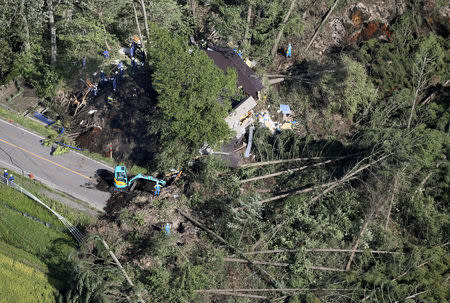 Police officers and rescue workers search for survivors from a building damaged by a landslide caused by a powerful earthquake in Atsuma town in Japan's northern island of Hokkaido, Japan, in this photo taken by Kyodo September 6, 2018. Mandatory credit Kyodo/via REUTERS ATTENTION EDITORS - THIS IMAGE WAS PROVIDED BY A THIRD PARTY. MANDATORY CREDIT. JAPAN OUT. NO COMMERCIAL OR EDITORIAL SALES IN JAPAN.