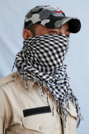 Twenty-four-year-old police officer who asked to remain anonymous, poses for a portrait in Kashmir, India May 19, 2017. REUTERS/Cathal McNaughton