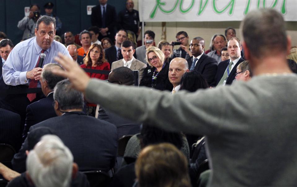 New Jersey Gov. Chris Christie, left, listens to a question during a town hall meeting in Brick Township, N.J., Thursday, April 24, 2014. Many questions at the town hall focused on the state's Sandy recovery efforts. (AP Photo/Mel Evans)