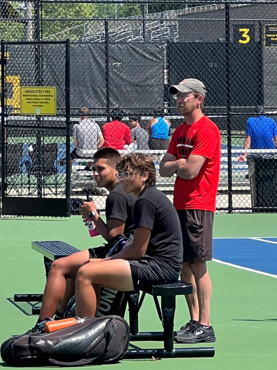 Alexander Lisiecki, sentado a la izquierda, Sebastian Lisiecki y Marion Harding, entrenador de tenis masculino, Dustin Ellis, de pie, toman un momento después de la competencia de dobles del torneo distrital de la División I del jueves en Upper Arlington High School.