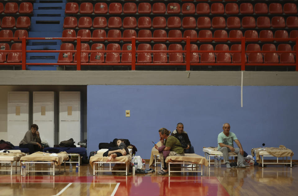 People rest at an indoor sport center in Larissa, Thessaly region, central Greece, Thursday, Sept. 7, 2023, after the country's record rainstorm. Widespread flooding in central Greece has left at least four people dead and six missing, with severe rainstorms turning streams into raging torrents, bursting dams, washing away roads and bridges, and hurling cars into the sea. (AP Photo/Vaggelis Kousioras)
