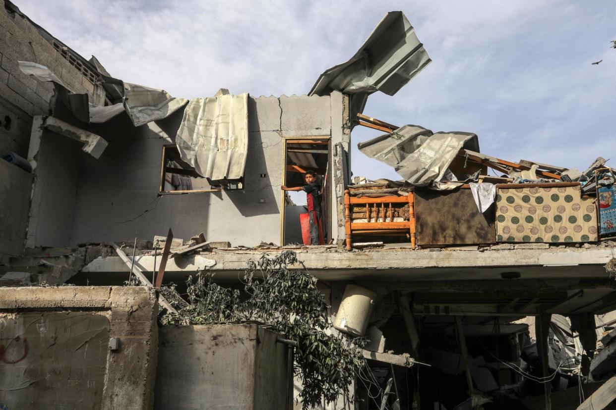 <span>A child looks out from a doorway after an Israeli attack on a home in Rafah, Gaza, on Thursday.</span><span>Photograph: Abed Rahim Khatib/Anadolu via Getty Images</span>