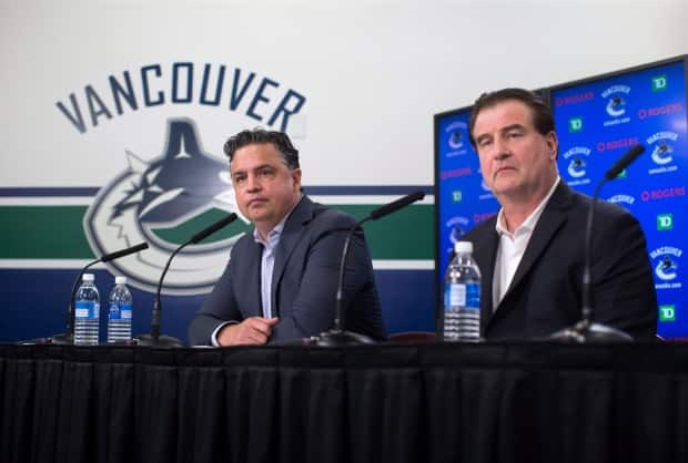 Vancouver Canucks head coach Travis Green, left, and general manager Jim Benning are pictured speaking to reporters on Friday.  (Darryl Dyck/The Canadian Press - image credit)