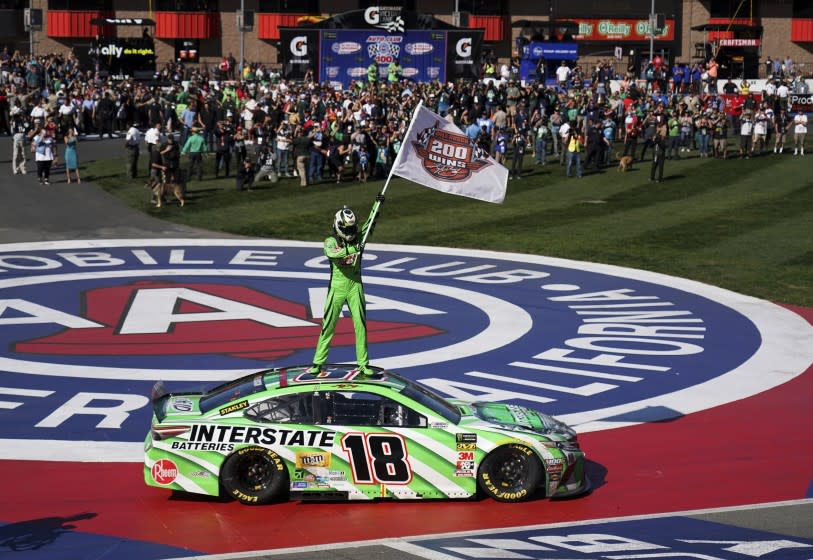 Kyle Buschs stands on his car after winning the NASCAR Cup Series race at Auto Club Speedway in Fontana on March 17, 2019.