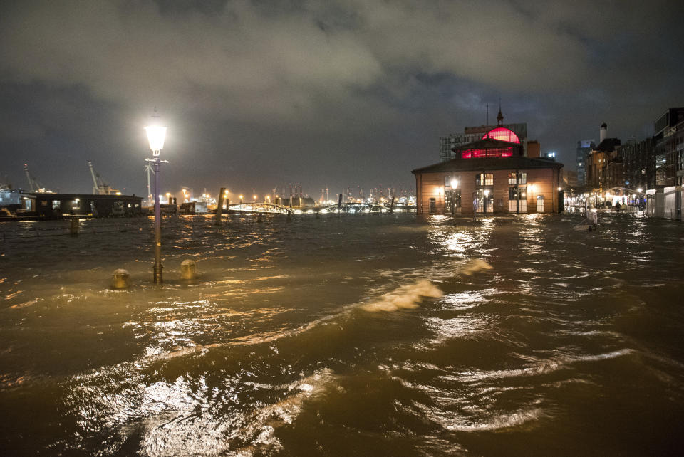 The fish market with the fish auction hall is flooded in the during a storm in Hamburg, Germany, Thursday, Feb. 17, 2022. Storm ‘Ylenia’ swept across Germany overnight, toppling trees and causing widespread delays to rail and air traffic, with meteorologists warning that further extreme weather is on the way. (Daniel Bockwoldt/dpa via AP)