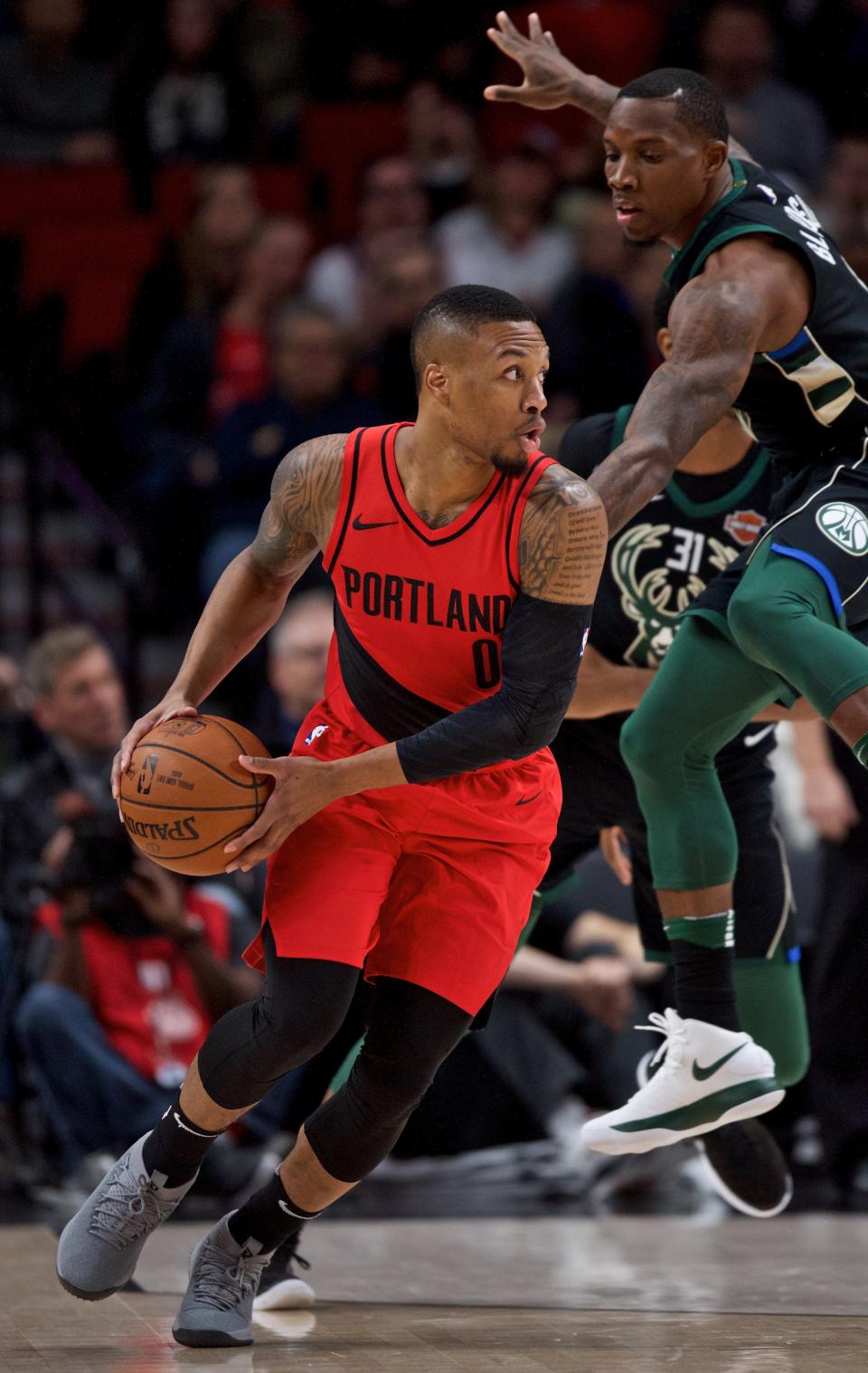 Portland Trail Blazers guard Damian Lillard spins around Milwaukee Bucks guard Eric Bledsoe.