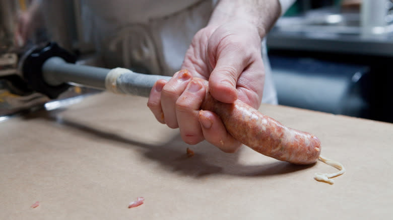 person stuffing sausage