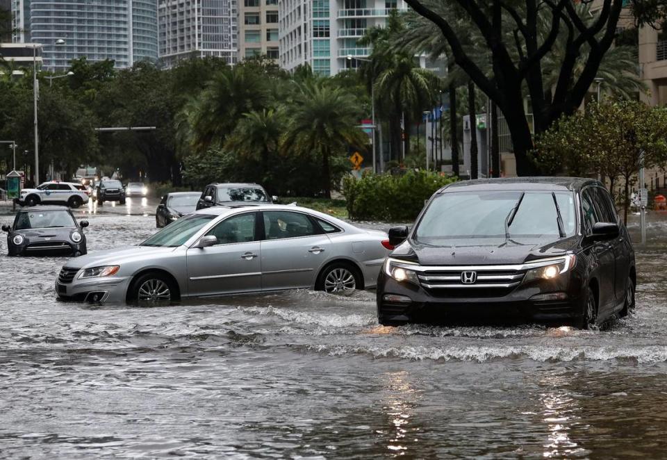 Vehicles navigate around immobile motorists as Tropical Storm Eta slammed into Miami, leaving drivers crossing the intersection of Southwest 13th Street and Brickell Avenue stuck in floodwater on Nov. 9, 2020.
