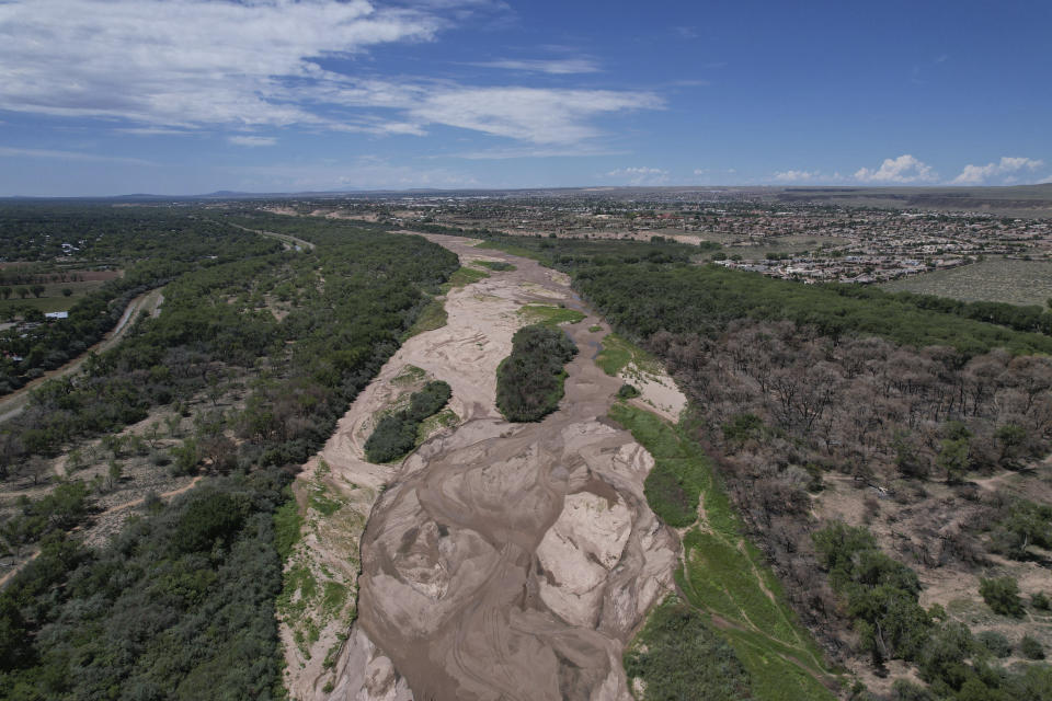 FILE - The dry Rio Grande riverbed is seen from the air, July 26, 2022, in Albuquerque, N.M. On Tuesday, June 27, 2023, some New Mexico lawmakers warned that the state’s fight with neighboring Texas over management of one of North America’s longest rivers has yet to be settled and that leaving farmland unplanted won’t be the long-term answer to ensuring Texas gets its share. (AP Photo/Brittany Peterson, File)