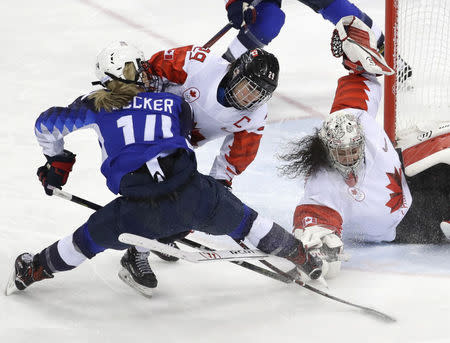 Brianna Decker of the U.S., Marie-Philip Poulin of Canada and goalie Shannon Szabados of Canada in action. REUTERS/David W Cerny