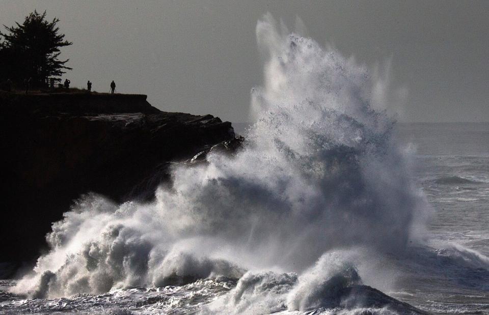 Waves crash on the rocks at Shore Acres State Park on the Oregon Coast during a king tide event on Jan. 22, 2023 as spectators watch from the overlook beyond.