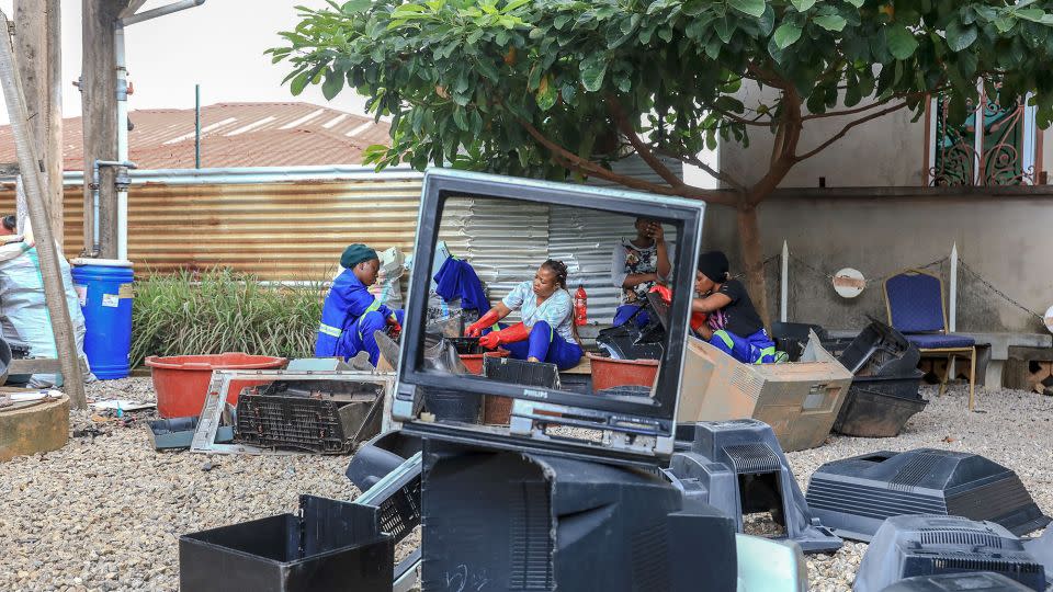 Women in Cameroon clean the casings of television sets in Yaounde on September 14, 2022. - Daniel Beloumou Olomo/AFP/Getty Images