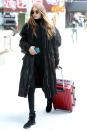 <p>In round sunglasses, a black turtleneck sweater, skinny jeans, suede booties, and an oversized parka while arriving to her apartment in NYC.</p>