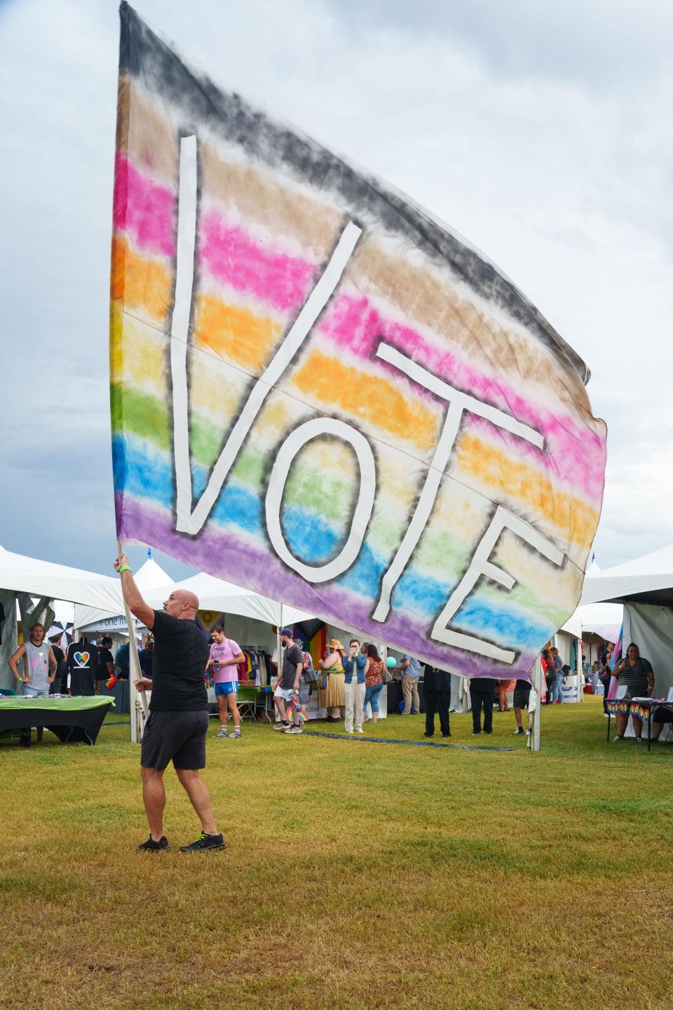Dave Watt waves a rainbow vote flag at the 41st Phoenix Pride Festival on Oct. 15, 2022, in Phoenix, Ariz.