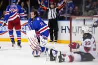 New York Rangers goaltender Igor Shesterkin (31) gets up after losing his helmet while stopping a shot by New Jersey Devils' Ryan Graves (33) during the second period of an NHL hockey game Friday, March 4, 2022, in New York. (AP Photo/Frank Franklin II)