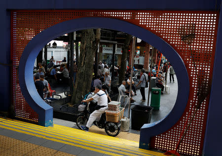 Elderly people sit outside a food centre at Chinatown in Singapore December 13, 2018. REUTERS/Edgar Su/Files