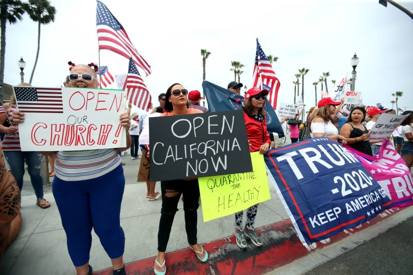 Protesters call for opening churches and lifting remaining virus restrictions in California during a protest Saturday in Huntington Beach.(Raul Roa / Los Angeles Times)