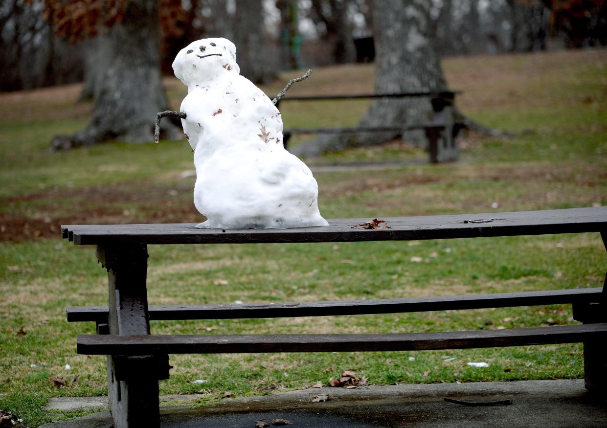 A diminishing snowman, a weekend remnant, sits atop a picnic table at Washington Park in Springfield Monday. More snow and rain are predicted for the area through Wednesday.