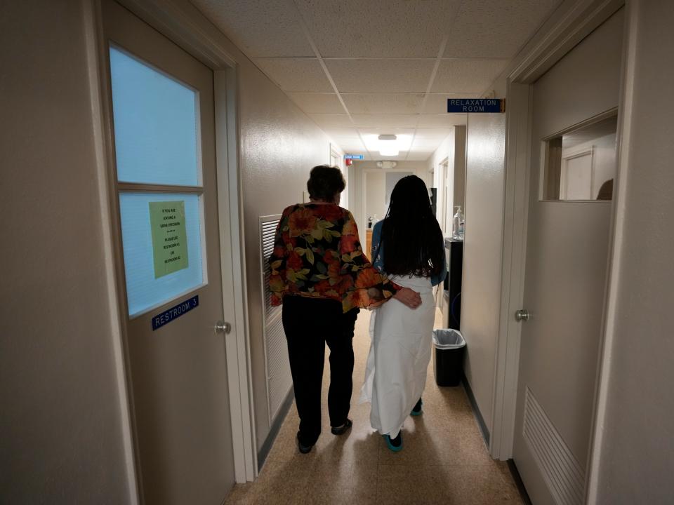 A 33-year-old mother of three from central Texas is escorted down the hall by clinic administrator Kathaleen Pittman prior to getting an abortion.