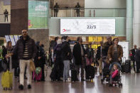 Soldiers patrol as passengers walk through the departure terminal, marking the one-year anniversary at Zaventem Airport in Brussels on Wednesday, March 22, 2017. The suicide bombings at the Brussels airport and subway on March 22, 2016, killed 32 people and wounded more than 300 others. (AP Photo/Geert Vanden Wijngaert)