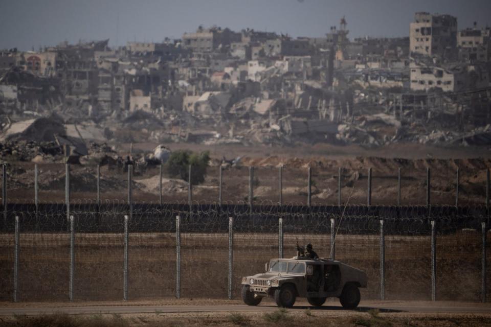 Israeli soldiers move near the Israeli-Gaza border on Monday, ahead of advancing further into Gaza City (AP)