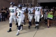 <p>Seattle Seahawks quarterback Russell Wilson (3) and center Justin Britt (68) walk to the field with arms linked after the national anthem had been played before an NFL football game between the Seahawks and the Tennessee Titans Sunday, Sept. 24, 2017, in Nashville, Tenn. Neither team was present on the field for the playing of the anthem. (AP Photo/Mark Zaleski) </p>