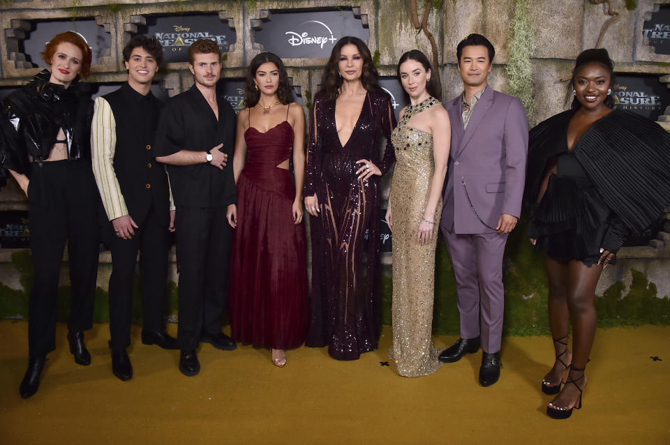 Breeda Wool, from left, Antonio Cipriano, Jake Austin Walker, Lisette Olivera, Catherine Zeta-Jones, Zuri Reed, Lyndon Smith and Jordan Rodrigues arrive at a red carpet event for "National Treasure: Edge of History," Monday, Dec. 5, 2022, at El Capitan Theatre in Los Angeles. (Photo by Jordan Strauss/Invision/AP)