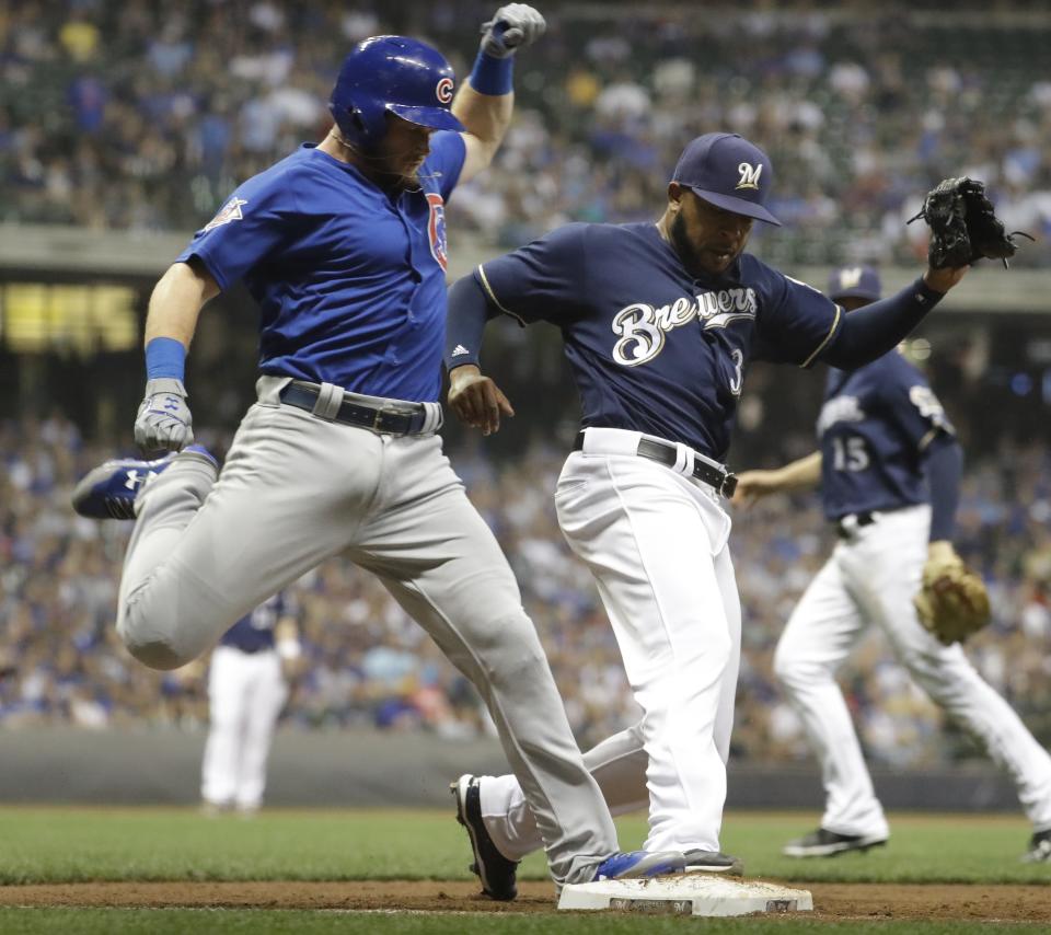 Chicago Cubs’ Ian Happ is safe at first as he beats Milwaukee Brewers’ Jeremy Jeffress to the bag during the ninth inning. (AP Photo)