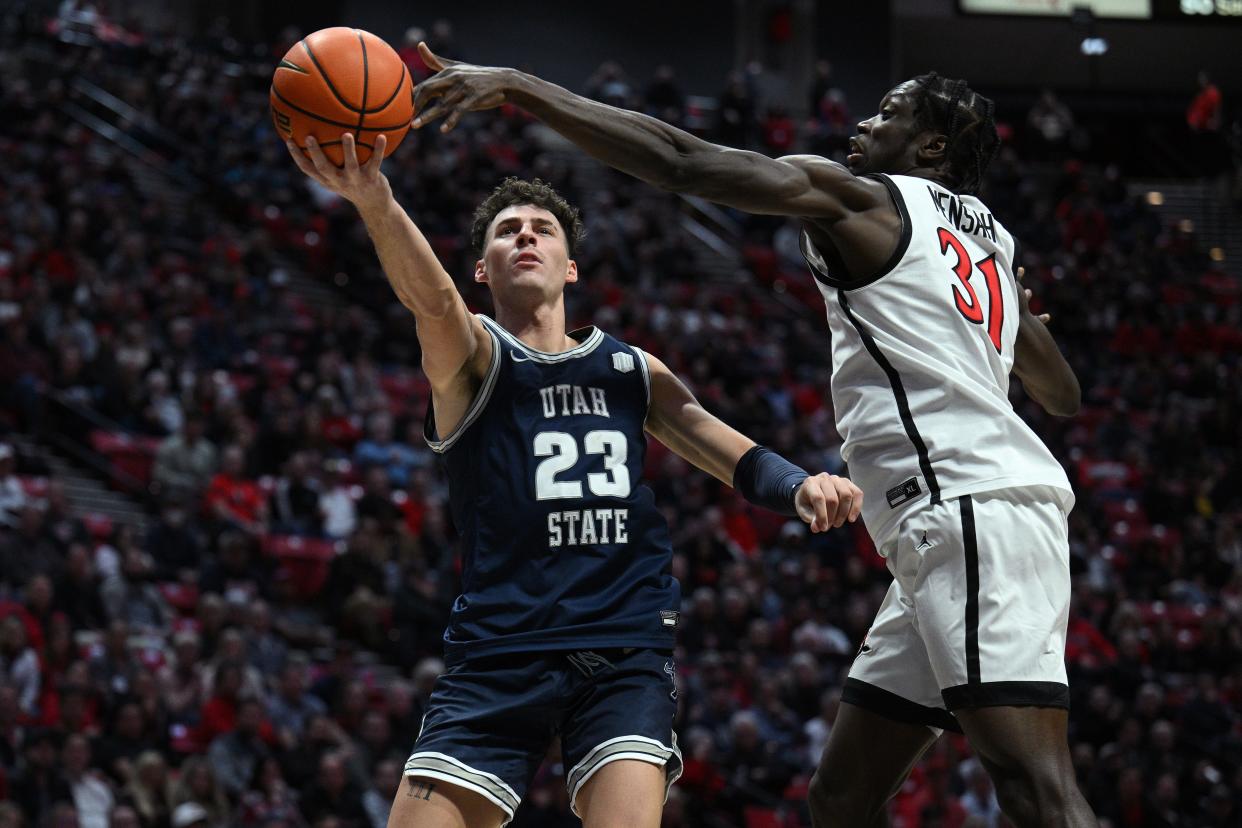 Utah State forward Taylor Funk (23) shoots the ball past San Diego State forward Nathan Mensah (31) during their game at Viejas Arena.