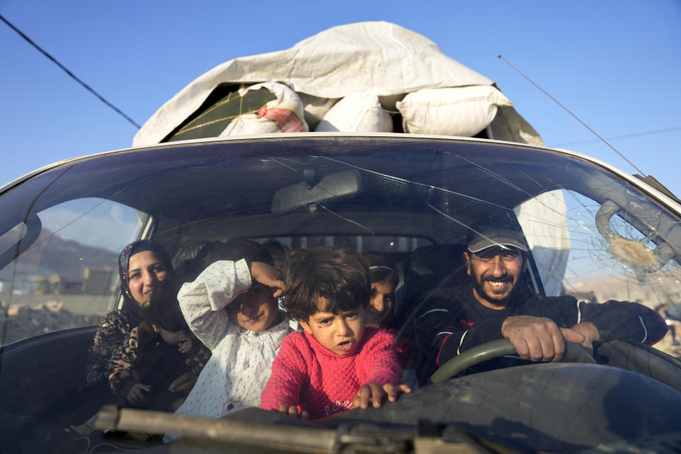 Syrian refugee family sit inside a pickup, as they wait at a gathering point to cross the border back home to Syria, in the eastern Lebanese border town of Arsal, Lebanon, Wednesday, Oct. 26, 2022. Several hundred Syrian refugees boarded a convoy of trucks laden with mattresses, water and fuel tanks, bicycles – and, in one case, a goat – Wednesday morning in the remote Lebanese mountain town of Arsal in preparation to return back across the nearby border.(AP Photo/Hussein Malla)